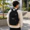 Person wearing a black laptop backpack while walking outdoors on a campus