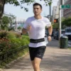 Man wearing a black running waist belt while jogging outdoors with hands-free storage